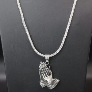 A delicate praying hand pendant elegantly suspended on a fine chain, symbolizing faith and spirituality.