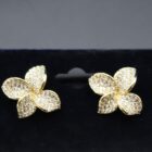 A pair of elegant gold earrings adorned with sparkling crystals, showcasing a refined and luxurious design.